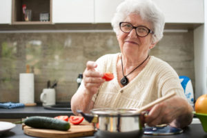 woman in kitchen wearing pendant