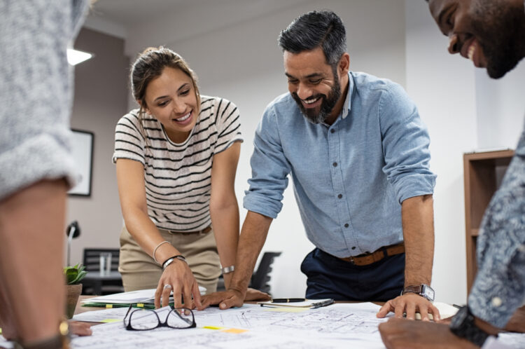 Workers standing around table collaborating
