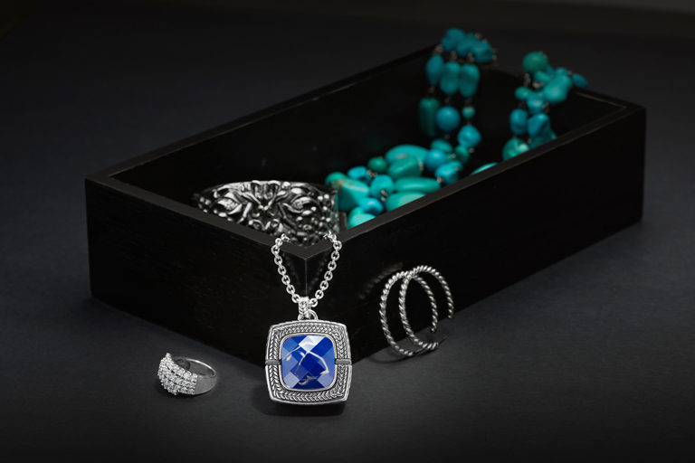 Jewelry in and around fancy box on table