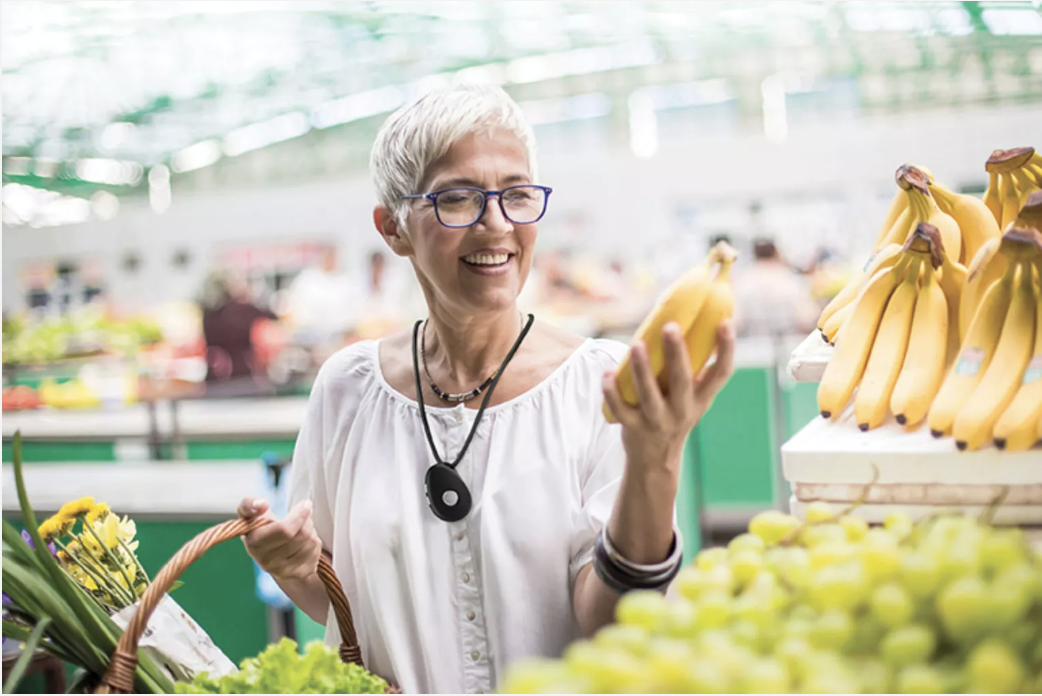 A Happy Woman Grocery Shopping Using Her Lifestation Mobile Medical Alert Necklace