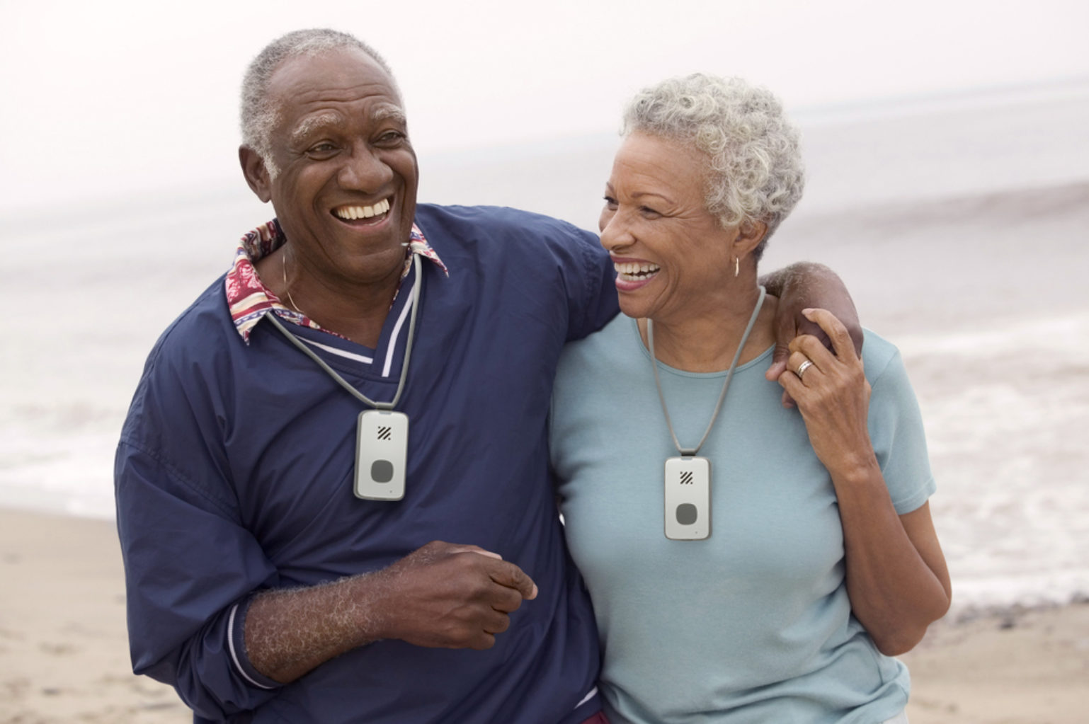 Man and woman on beach with medical alerts around neck