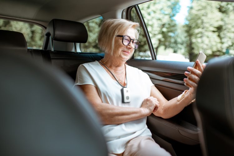 Elderly woman in the car looking at phone