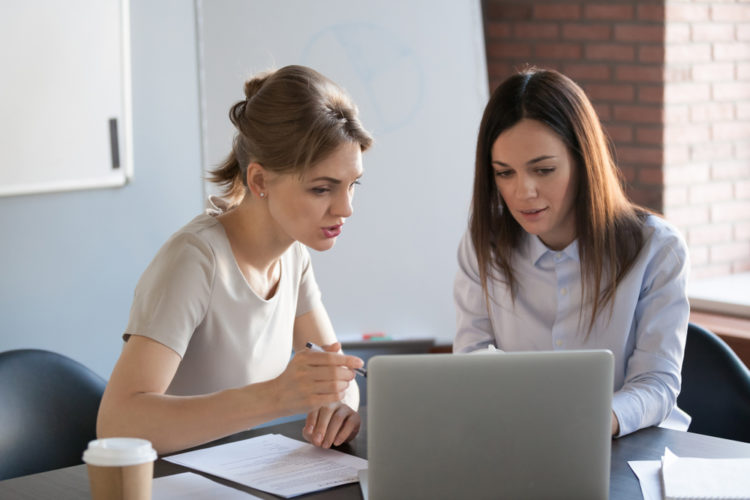 Two women sitting with laptop