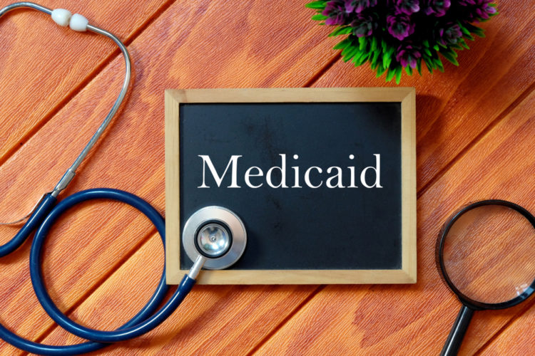 Table with stethoscope, magnifying glass, and medicaid written on a small blackboard