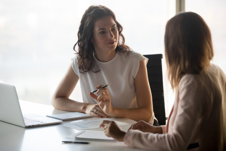 Adults sitting at table working in office