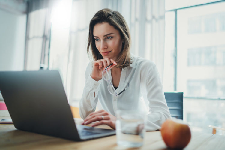 Woman sitting at desk with laptop on table