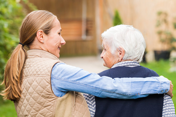 Woman walking with elderly lady outside