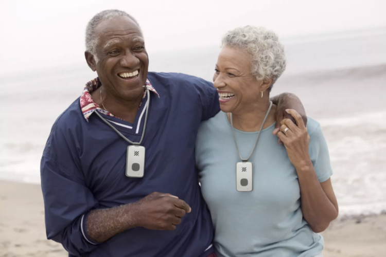 Two People Happily Using Their Lifestation Mobile GPS Medical Alert System Necklaces